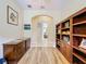 Hallway featuring wood floors, an arched entryway, and built-in shelving at 3551 Mulberry Grove Loop, Leesburg, FL 34748
