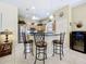 Well-lit kitchen with barstool seating, wooden cabinetry, and modern stainless-steel appliances at 3551 Mulberry Grove Loop, Leesburg, FL 34748