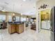 Open concept kitchen features modern appliances, breakfast bar, and seamless flow into the living area and laundry room at 3551 Mulberry Grove Loop, Leesburg, FL 34748
