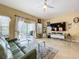 Bright living room with a ceiling fan and sliding glass doors opening to an outdoor space at 3551 Mulberry Grove Loop, Leesburg, FL 34748