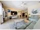 Stylish living room featuring a ceiling fan, large television, and tile flooring at 3551 Mulberry Grove Loop, Leesburg, FL 34748