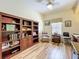 Bright home office featuring built-in bookshelves and wood floors at 3551 Mulberry Grove Loop, Leesburg, FL 34748