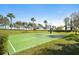 Full-sized basketball court surrounded by lush greenery and tall palm trees at 3656 Solana Cir # A, Clermont, FL 34711