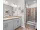 Bathroom featuring double sinks, tile flooring, and a glass-enclosed shower at 3656 Solana Cir # A, Clermont, FL 34711
