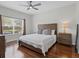Well-lit bedroom features a wooden bed frame, bedside table, and large window at 3656 Solana Cir # A, Clermont, FL 34711