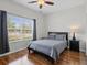 Bedroom with wood floors, a double bed, and a large window with blinds and curtains at 3656 Solana Cir # A, Clermont, FL 34711