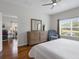 Sunlit main bedroom features wood floors, a dresser, and views of the front yard at 3656 Solana Cir # A, Clermont, FL 34711