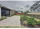 Paver patio in a landscaped backyard featuring a screened-in porch and fencing at 368 Alcove Dr, Groveland, FL 34736