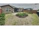 Landscaped backyard featuring grass, mulch, shrubbery and a view of the neighbors pool enclosure at 368 Alcove Dr, Groveland, FL 34736