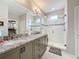 Spacious bathroom features double sink vanity with granite countertop, glass shower, and ample storage space at 368 Alcove Dr, Groveland, FL 34736