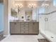 Bathroom featuring double sink vanity with granite countertop, glass shower, modern lighting, and neutral tones at 368 Alcove Dr, Groveland, FL 34736