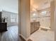 View of an ensuite bathroom featuring a walk-in shower, double vanities, modern fixtures, and neutral finishes at 368 Alcove Dr, Groveland, FL 34736