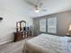 Cozy bedroom featuring a ceiling fan, wood-look floors, a large dresser, and two large windows at 368 Alcove Dr, Groveland, FL 34736