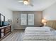 Bright bedroom featuring a ceiling fan, wood-look floors, a large dresser with mirrors, and two large windows at 368 Alcove Dr, Groveland, FL 34736