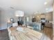Inviting dining area with a rustic wooden table, modern lighting, and a seamless transition to the kitchen at 368 Alcove Dr, Groveland, FL 34736