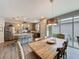 Well-lit dining room adjacent to a modern kitchen with stainless steel appliances and access to outdoor patio at 368 Alcove Dr, Groveland, FL 34736