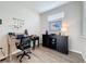 Well-lit home office with wood-look tile, desk and stylish decor at 368 Alcove Dr, Groveland, FL 34736