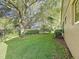 Well-maintained backyard with lush lawn, mature trees, and manicured hedges at 3684 Eversholt St, Clermont, FL 34711