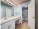 Bathroom features an extended white vanity with a large mirror and a walk-in shower with glass doors at 3684 Eversholt St, Clermont, FL 34711