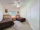 Bright bedroom with twin beds, ceiling fan, and a window offering ample sunlight and closet access at 3684 Eversholt St, Clermont, FL 34711