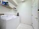 Laundry room with tile flooring features a washer, dryer, shelving, and storage space at 3684 Eversholt St, Clermont, FL 34711