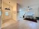 Open-concept living space with tile flooring, modern light fixtures, and a view into the kitchen and dining area at 3684 Eversholt St, Clermont, FL 34711