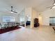 Open-concept living space with tile flooring, a mirrored wall, and views into the kitchen, dining area, and bedroom at 3684 Eversholt St, Clermont, FL 34711