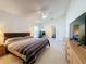 Primary bedroom with TV, tile flooring, and access to additional room at 3684 Eversholt St, Clermont, FL 34711