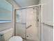 Shower room features a window and tiled shower with glass doors and grab bars for accessibility at 3684 Eversholt St, Clermont, FL 34711