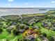 Aerial view of a single-Gathering home on a golf course with mature trees and overlooking a lake in the distance at 39023 Griffin Lndg, Lady Lake, FL 32159