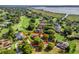 Aerial view of a single-Gathering home on a golf course, surrounded by mature trees and lush landscaping at 39023 Griffin Lndg, Lady Lake, FL 32159