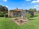 Landscaped backyard with decorative brickwork, lush lawn, screened lanai, offering an ideal space for relaxation and outdoor enjoyment at 39023 Griffin Lndg, Lady Lake, FL 32159