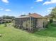 Backyard with a screened lanai, decorative brickwork, lush lawn, and manicured landscaping, creating a serene outdoor oasis at 39023 Griffin Lndg, Lady Lake, FL 32159