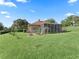 Backyard view of a single-Gathering home with a screened lanai, landscaped garden beds, and a lush lawn at 39023 Griffin Lndg, Lady Lake, FL 32159