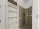 Bright bathroom displays an open shelving unit with floral trim next to a tiled shower at 39023 Griffin Lndg, Lady Lake, FL 32159