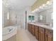 Bright bathroom features a chandelier, double vanity, soaking tub, and glass shower at 39023 Griffin Lndg, Lady Lake, FL 32159