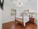 This bedroom features a hardwood floor, ceiling fan, and a window with wood blinds at 39023 Griffin Lndg, Lady Lake, FL 32159