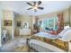 Charming bedroom featuring tile floors, a bright window with shutters, and soft, neutral decor at 39023 Griffin Lndg, Lady Lake, FL 32159
