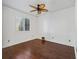 This bedroom features hardwood floors, a ceiling fan, and a window with wood blinds at 39023 Griffin Lndg, Lady Lake, FL 32159