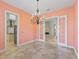 Elegant dining room featuring a decorative chandelier and French doors leading to a living area with a stone fireplace at 39023 Griffin Lndg, Lady Lake, FL 32159