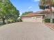 Long brick driveway leads to a three-car garage with well-maintained landscaping at 39023 Griffin Lndg, Lady Lake, FL 32159