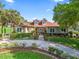 Charming home featuring a stone facade,dormer windows, and a beautifully landscaped front yard and a circular drive at 39023 Griffin Lndg, Lady Lake, FL 32159