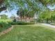 Lush green lawn surrounds a home with stone accents and manicured bushes at 39023 Griffin Lndg, Lady Lake, FL 32159