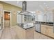 Bright kitchen with an island cooktop, stainless steel appliances, and large windows offering views of the backyard at 39023 Griffin Lndg, Lady Lake, FL 32159