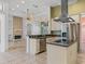 Open-concept kitchen with island cooktop, breakfast bar, stainless steel appliances, and views to the fireplace at 39023 Griffin Lndg, Lady Lake, FL 32159