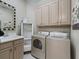Convenient laundry room with sink, open shelving, and washer and dryer at 39023 Griffin Lndg, Lady Lake, FL 32159