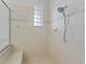 Tiled shower stall features glass block window, hand-held shower, and built-in seat at 39023 Griffin Lndg, Lady Lake, FL 32159