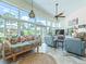 Bright sun room with tile floors, floor-to-ceiling windows overlooking the landscaped backyard, and stylish furnishings at 39023 Griffin Lndg, Lady Lake, FL 32159