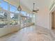 Bright sunroom with floor-to-ceiling windows, tiled floor, and views of the manicured backyard at 39023 Griffin Lndg, Lady Lake, FL 32159
