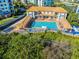 Beautiful aerial shot of the community pool, deck, and surrounding lush landscape at 5300 S Atlantic Ave # 16-202, New Smyrna Beach, FL 32169